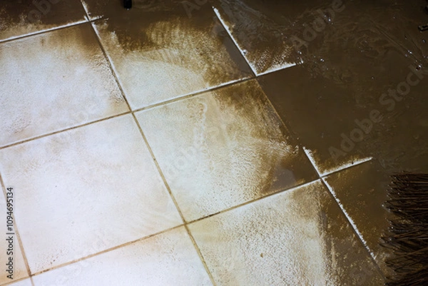 Fototapeta A dirty tile floor with a white tile in the middle. The white tile is covered in dirt and grime