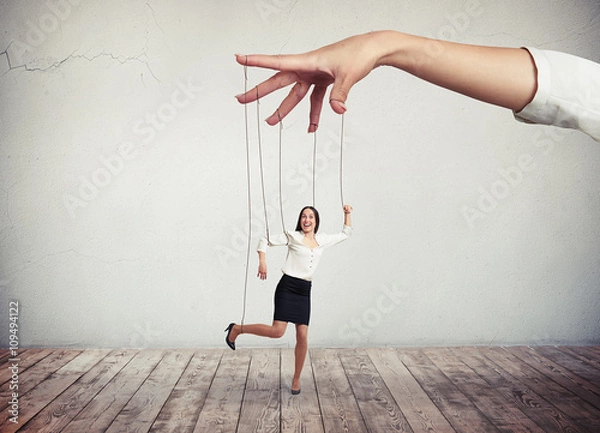 Fototapeta Woman looks like a puppet on strings