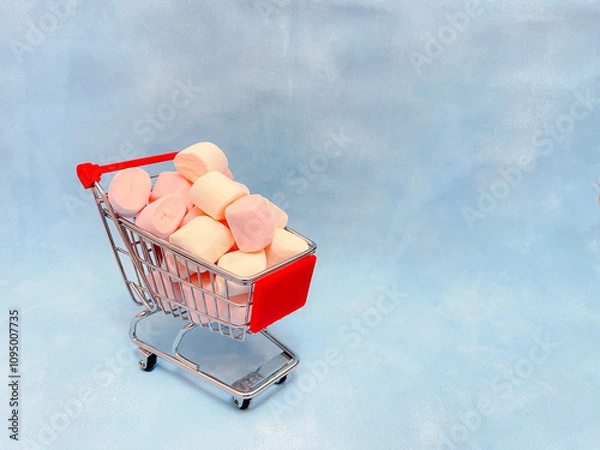 Obraz Miniature cart from a supermarket with marshmallows. Blue background