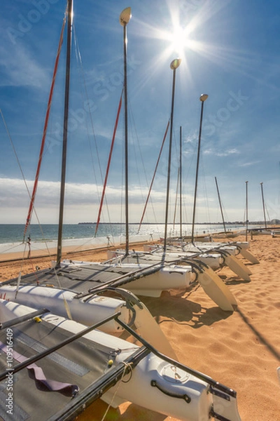 Fototapeta Katamaran pusty. Katamaran składowany na plaży w La Baule we Francji na błękitnym niebie.