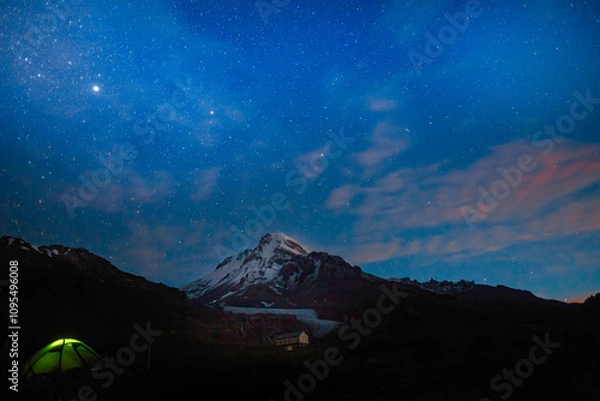 Fototapeta Mountain's snowy peak Kazbek (Kazbegi), Caucasus stands sentinel in the cosmic blue night sky