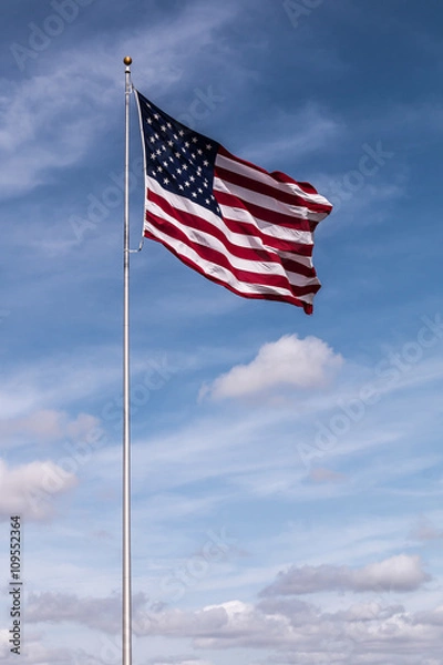 Obraz Single American Flag with a cloudy blue sky background.