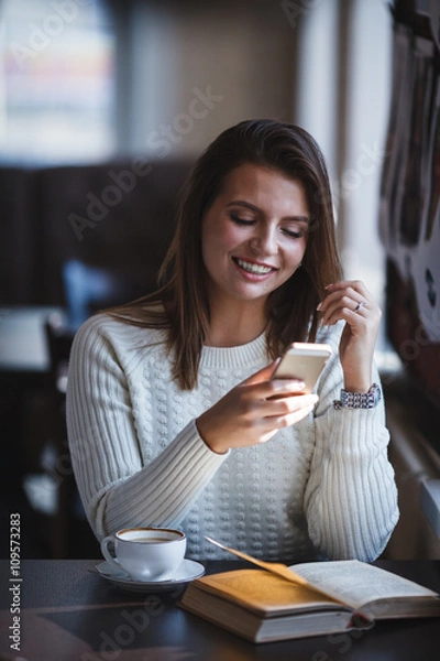 Obraz woman using her mobile phone at cafe