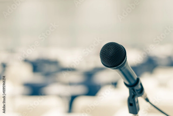 Fototapeta Microphone voice speaker in seminar classroom, lecture hall, town hall meeting or conference forum in educational business event for coaching host or teacher with audiences or students seats