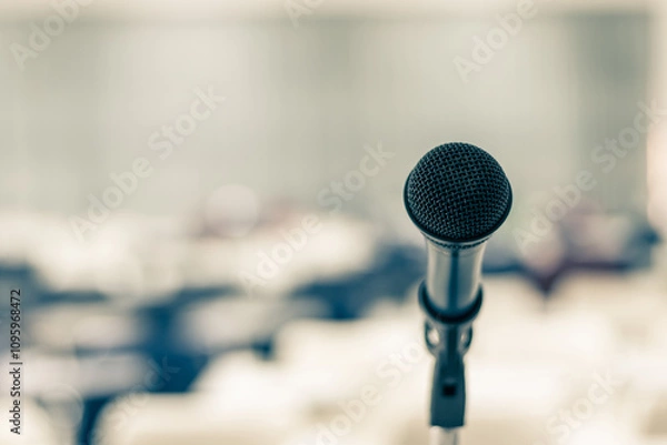 Fototapeta Microphone voice speaker in seminar classroom, lecture hall, town hall meeting or conference forum in educational business event for coaching host or teacher with audiences or students seats