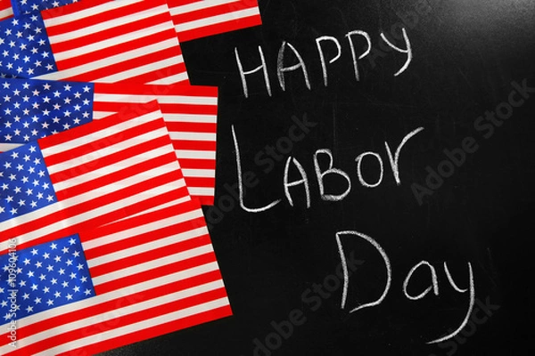 Fototapeta Happy Labour Day text and USA national flags on blackboard