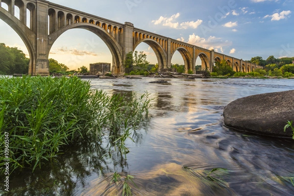 Obraz Richmond Railroad Bridge oświetlony słońcem / Wdzięczne łuki mostu kolejowego na rzece James w Wirginii oświetlone są przez zachodzące słońce.
