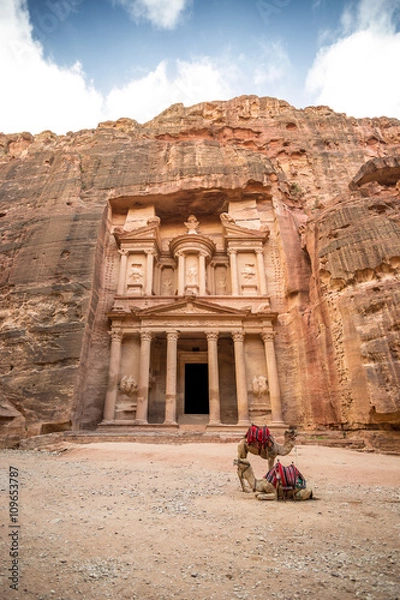 Fototapeta Widok z przodu słynnego Al-Khazneh (aka skarbowy) z wielbłądami odpoczywającymi obok niego w starożytnym mieście Petra (Jordan)
