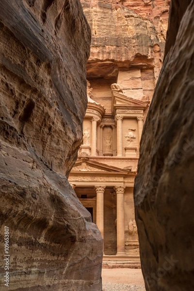 Fototapeta Hiking through the canyon in the ancient city of Petra (Jordan) - opening view of the famous Al-Khazneh (aka Treasury)