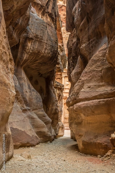Fototapeta Hiking through the canyon in the ancient city of Petra (Jordan) - opening view of the famous Al-Khazneh (aka Treasury)