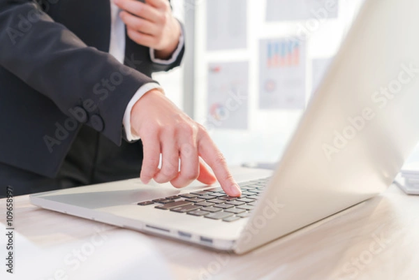 Fototapeta Closeup of business woman hand typing on laptop keyboard