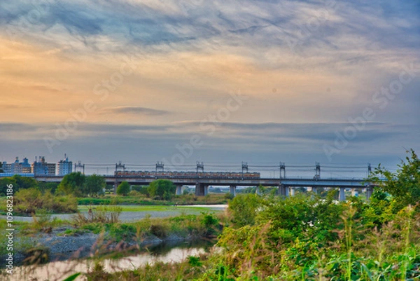 Fototapeta 夕焼けの中を走る電車