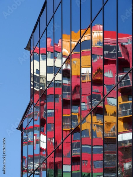 Fototapeta Wohnhaus in Örnsköldsvik spiegelt sich in einer Glasfassade eine