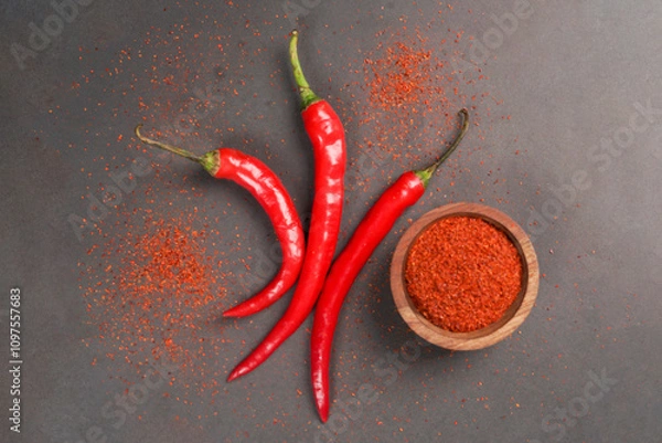 Obraz Large red chili and chilli powder served on wooden bowk isolated on a black background