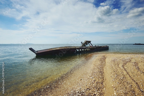 Fototapeta The shipwrecked fishing boat stands as a testament to the relentless power of the sea and the passage of time.