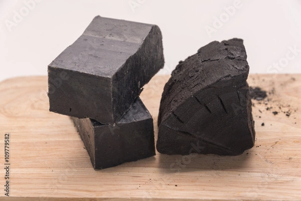 Fototapeta carbon soap  and a pile of coal on wooden tray