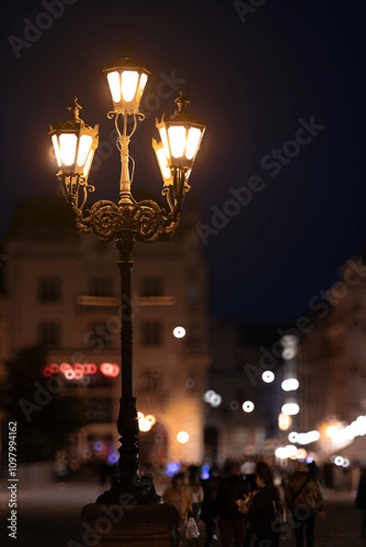 Fototapeta historical city square night long exposure view of people blurred motion and lantern warm electric light vertical photography