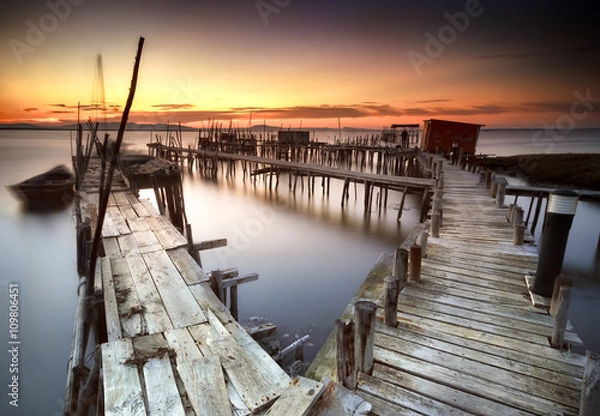 Obraz Ancient fishing pier with warm and beautiful sunset