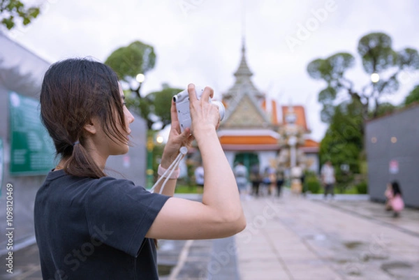 Fototapeta Tourists Examining Map Near Illuminated Temple