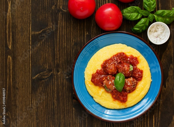 Fototapeta Homemade meatballs in tomato sauce with polenta as a garnish.