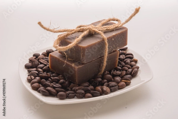 Fototapeta Traditional home made natural coffee soap with a pile of coffee beans on the background suggesting healthy organic non toxic wash products