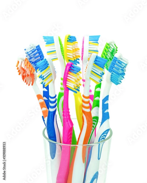 Obraz Десять разноцветных зубных щеток в стеклянном стакане на изолированном белом фоне
