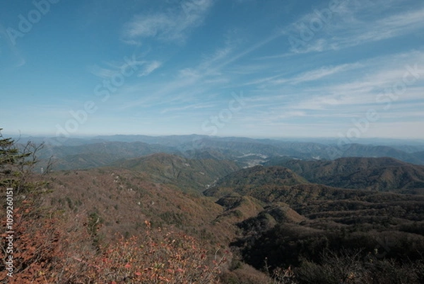 Fototapeta 대한민국 한반도 태백산맥의 산봉우리 정상에서 바라본 푸른 하늘의 구름과 가을 낙옆 단풍 나무숲 능선의 광활하고 시원한 풍경 배경화면