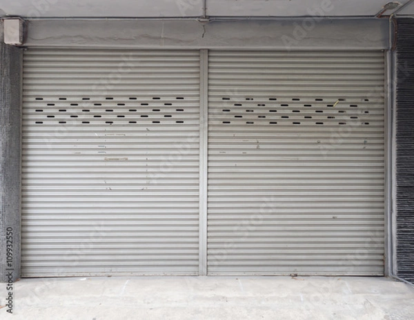 Obraz Old building with a rusty roller shutter door