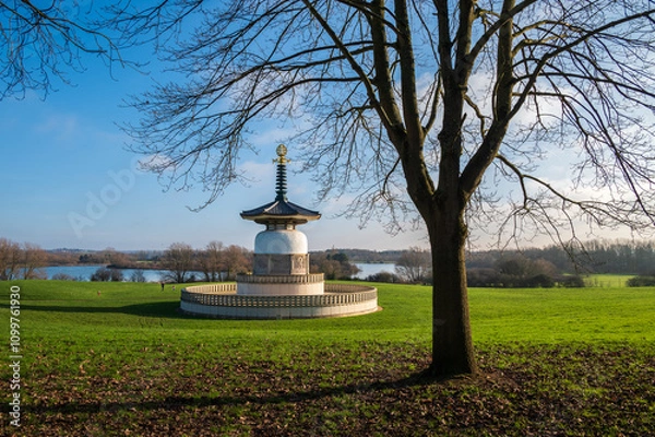 Obraz A serene January morning frames the Peace Pagoda, a solitary leafless tree, and the tranquil expanse of North Willen Lake in the distance