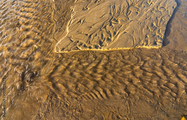Fototapeta Pequeñas olas en un riachuelo en una playa de arena