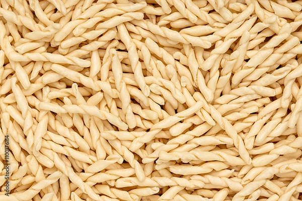 Fototapeta Macro photography of raw pasta strozzapreti, macaroni; twisted noodles; durum wheat semolina; traditional italian food 