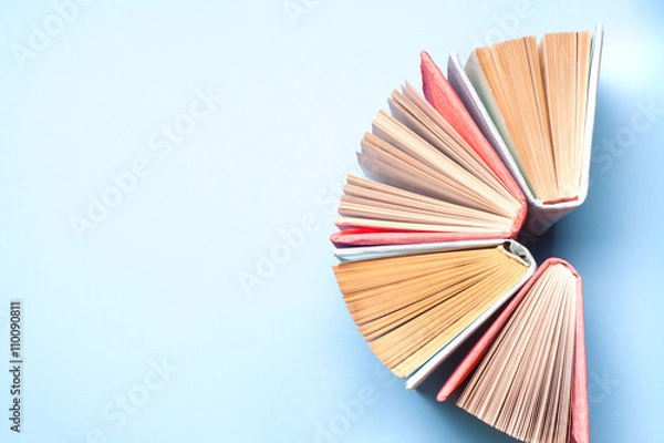 Fototapeta Top view of bright colorful hardback books in a circle. Open book, fanned pages.   Education essential for self improvement, gaining knowledge and success in our careers, business and personal lives.