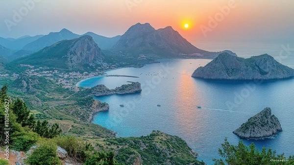 Obraz A serene sunset over a coastal landscape with mountains and calm waters.