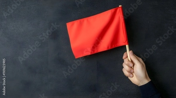 Fototapeta Person Holding a Red Flag Against a Dark Background Symbolizing Warning or Alert in Business Context