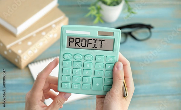 Fototapeta PROFIT text written on a calculator next to the background of euro banknotes.
