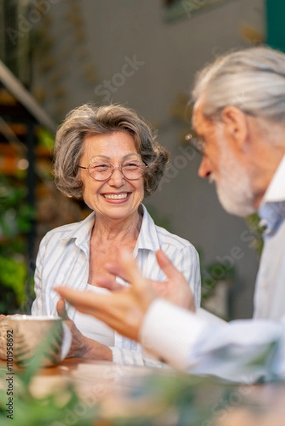 Fototapeta close up home happy old age an elderly couple pleasant memories leisure in old age a couple sitting at the table drinking tea discussing the news caring in old age pouring tea into cups