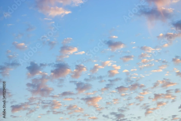Fototapeta A beautiful sky tinted by the sun leaving vibrant shades of gold, pink, blue and multicolored. Clouds in the twilight evening and morning sky. Cloudy sky background in the evening, and during the day.
