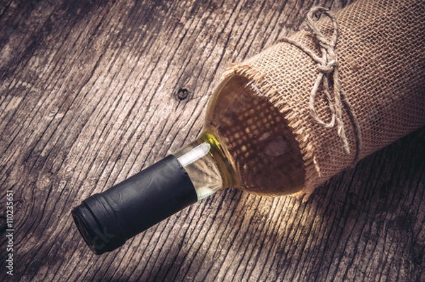 Fototapeta Bottle of white wine on rustic wooden background