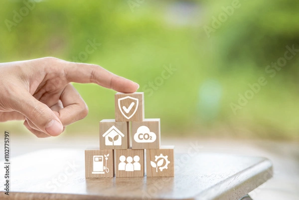 Obraz Hands are placing wooden blocks with icons representing environmentally friendly elements such as fuel, habitat, CO2 emissions, community and sustainability.