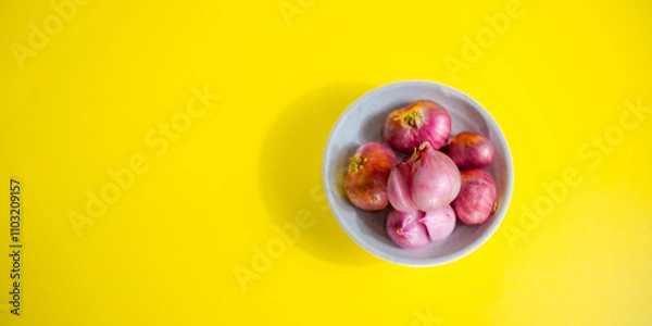 Fototapeta red onion in white bowl on yellow background 