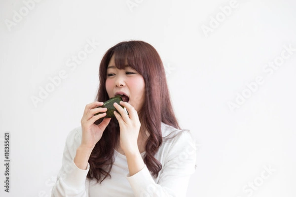 Fototapeta おにぎりを食べる女性(白バック)