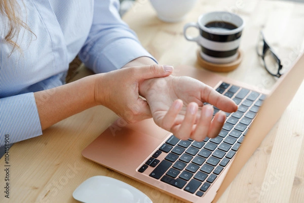Obraz Young woman with wrist pain while using laptop