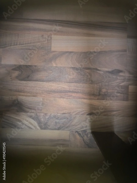 Fototapeta An abstract view of laminate seen through a glass coffee table, with light reflecting off the surface. The geometric shapes and textures create a visually intriguing, modern design.