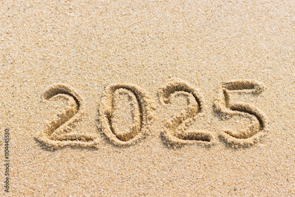 Fototapeta New Year 2025 concept. Numbers written on sand