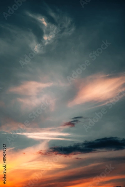 Fototapeta Dramatic sunset sky with soft, colorful clouds blending hues of orange, red, and blue. Scenic atmosphere.
