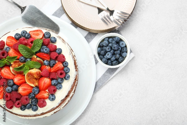 Fototapeta Delicious chocolate sponge cake with berries served on light table, flat lay. Space for text