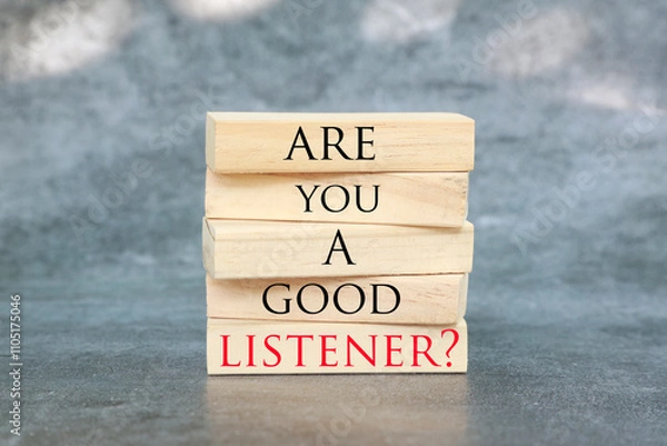 Fototapeta Listening skills symbol written on Wooden blocks with words Are you a good Listener. Beautiful grey background. Business and Are you a good Listener concept. Copy space.