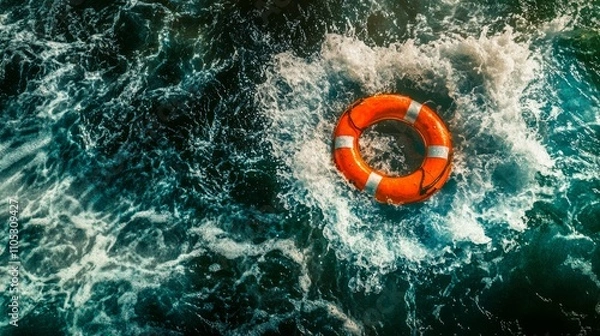 Fototapeta Bright lifebuoy centered among swirling ocean waves in motion.