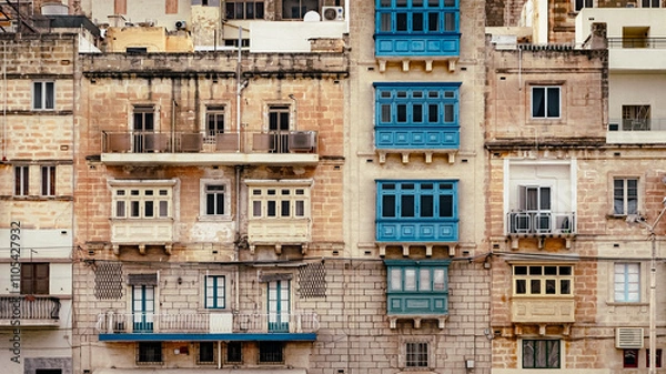 Fototapeta Typical Maltese wooden balconies on the facade of a row of houses, frontal view.