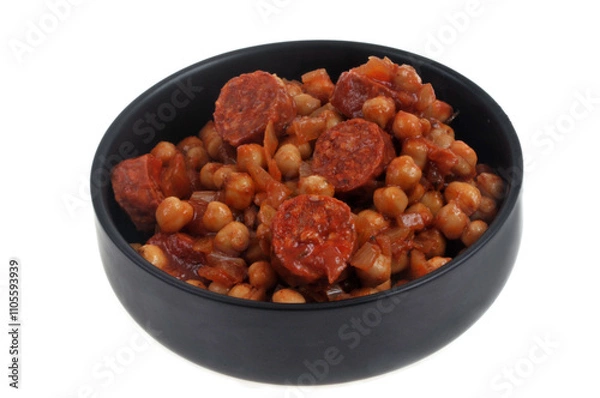 Obraz Ramequin de pois chiches et rondelles de chorizo en gros plan sur fond blanc